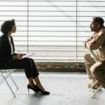 Photo of Man and Woman Sitting Beside Window