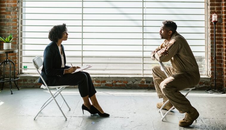 Photo of Man and Woman Sitting Beside Window